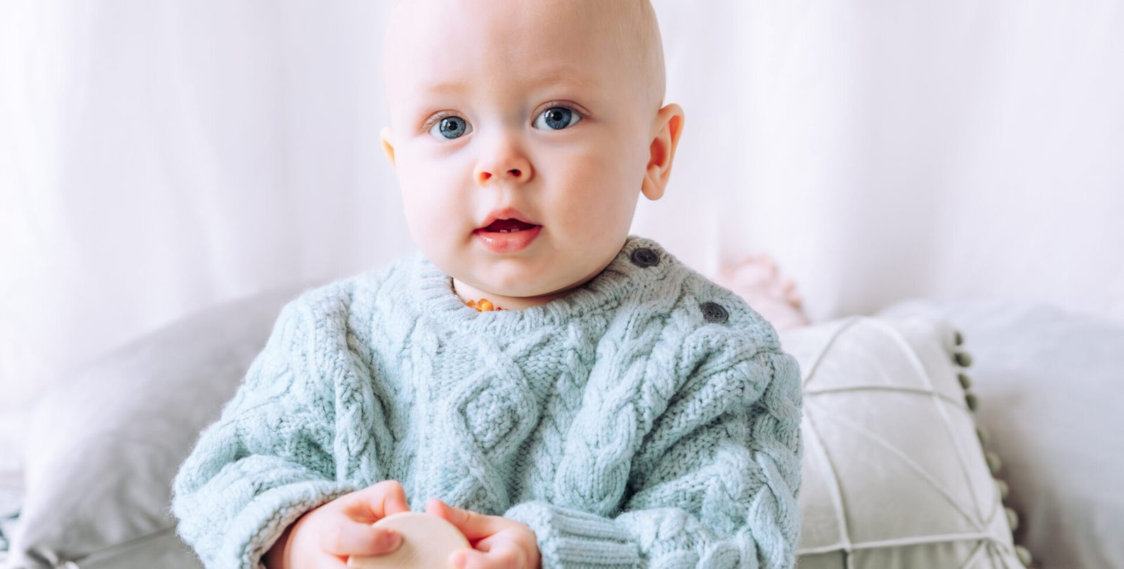 Baby sat in the studio looking into the camera with beautiful big blue eyes